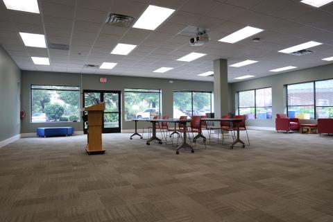 carpeted room with tables and chairs