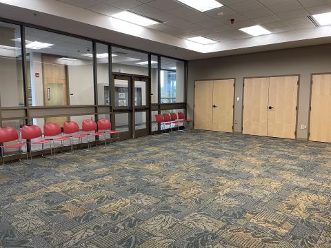 carpeted empty room, one glass wall