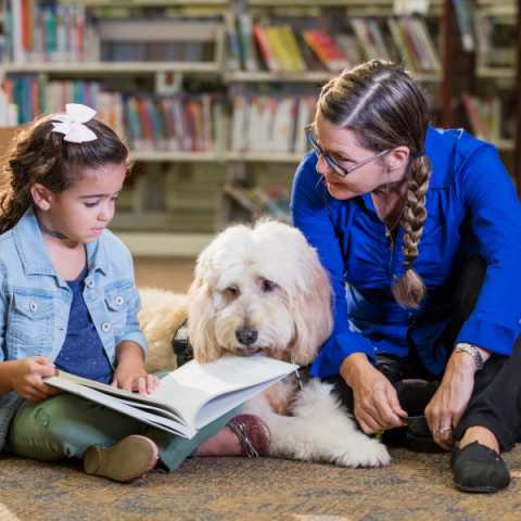 Child reads to a therapy dog