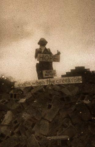 Grainy, sepia-toned photograph of figure atop rubble pile, with signs reading "HOPE" and "even when the creek rises"