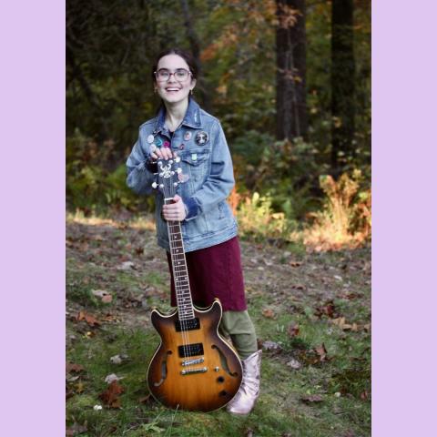 photo of Elvenqueen in the woods with her guitar