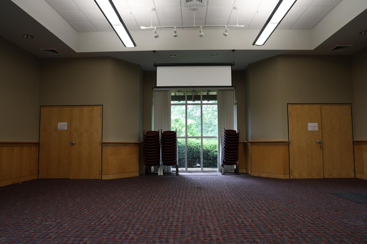 carpeted room with three stacks of chairs